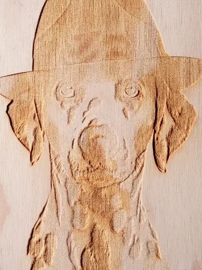 Portrait de chien gravé en relief dans le bois