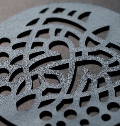 Disque de cuir gris ardoise ajouré d'un motif organique
