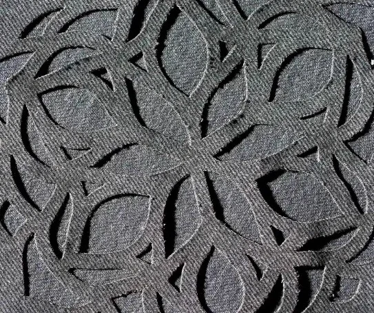 Tissu gris découpé au laser d'un motif végétal ajouré