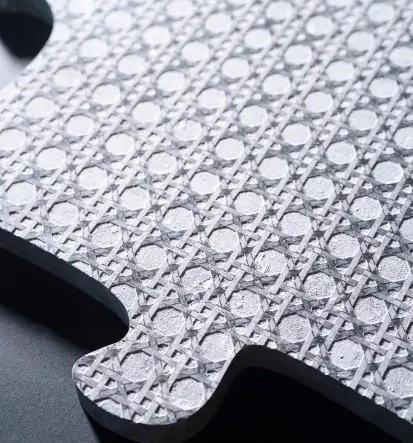 Pièce de pierre claire gravée d'un cannage et découpée en puzzle