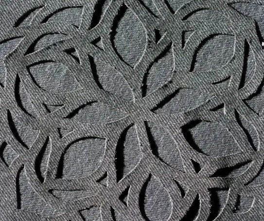 Tissu gris découpé au laser d'un motif végétal ajouré