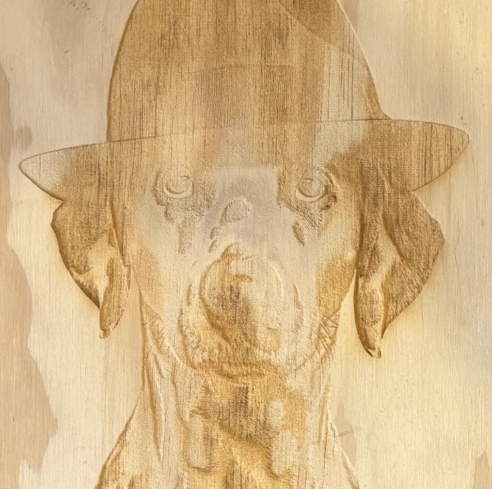 Portrait de chien gravé en relief dans le bois