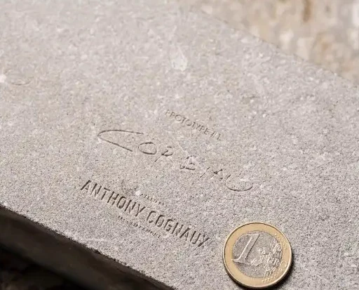 Signature gravée dans la pierre bleue, échelle donnée par une pièce d'un euro